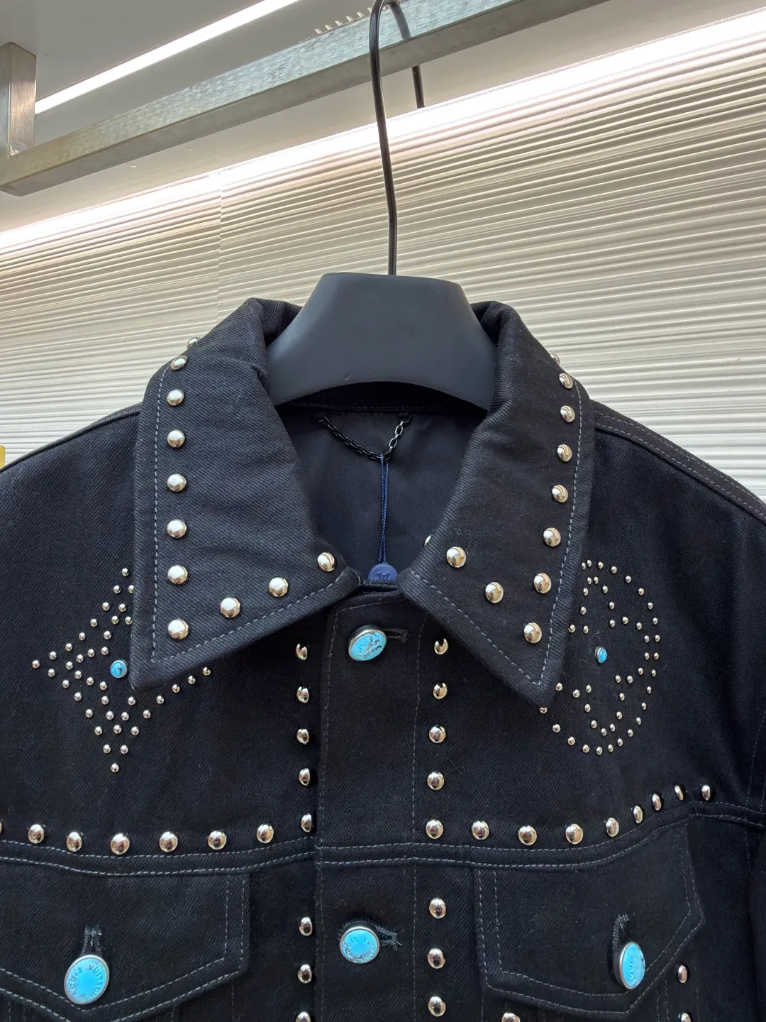 LOUIS VUITTON turquoise rivet denim jacket ●Original version: purchased and developed by 38979 ●Item number: 1682224-E30 ●Material: denim fabric ●Technology: hand-made rivet inlay ●Color: black ●Version: fitted version ●Weight: about 1550 grams ●Size: 46-48-50-52 ●Description: This black denim jacket is made of high-density twill denim fabric and has been treated with pre-washing water. It not only retains the crisp texture of the fabric, but also achieves a soft and skin-friendly wearing experience. The entire body of the garment is made of hand-made rivet inlay technology. The metal rivets are arranged at precise points to outline the outline of the brand's classic logo. Each rivet is manually hammered and fixed to ensure firmness and three-dimensionality. The placket and pockets are decorated with turquoise-textured resin buttons, which contrast with the metal rivets. The stitching on the collar, cuffs and hem adopts a double stitching process to enhance structural stability, while the edges are roughened to add a retro texture. The overall cut is a slightly loose Oversize version, combined with the three-dimensional tailoring process of the three-dimensional shoulder line, taking into account both styling and wearing comfort. Every detail is calibrated by hand, demonstrating the exquisite level of clothing making technology. The overall wiring is straight and delicate, the fabric is comfortable and soft, and the color is consistent without color difference. It can be matched with the same style to create a fashionable look and control various occasions. Customized accessories, complete with three standards, same style for men and women!